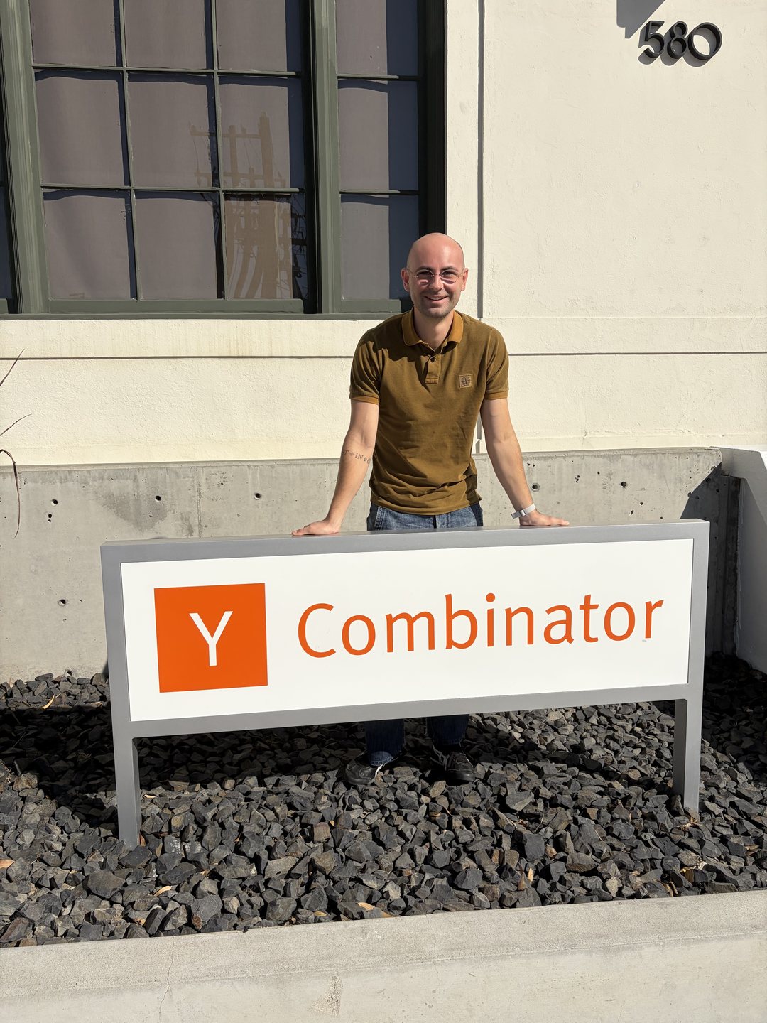 Enrico Milletti, founder of Sylica Robots, standing behind the Y Combinator sign